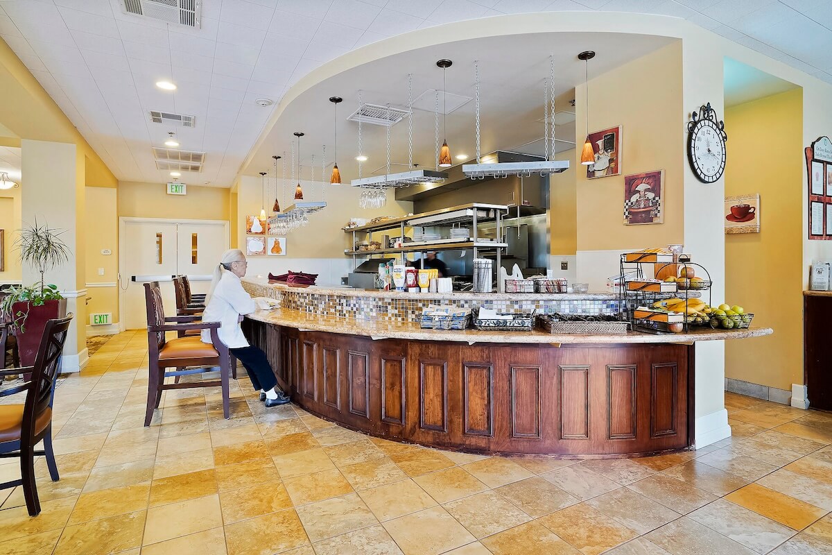 Interior of a bistro with a senior woman sitting at the counter