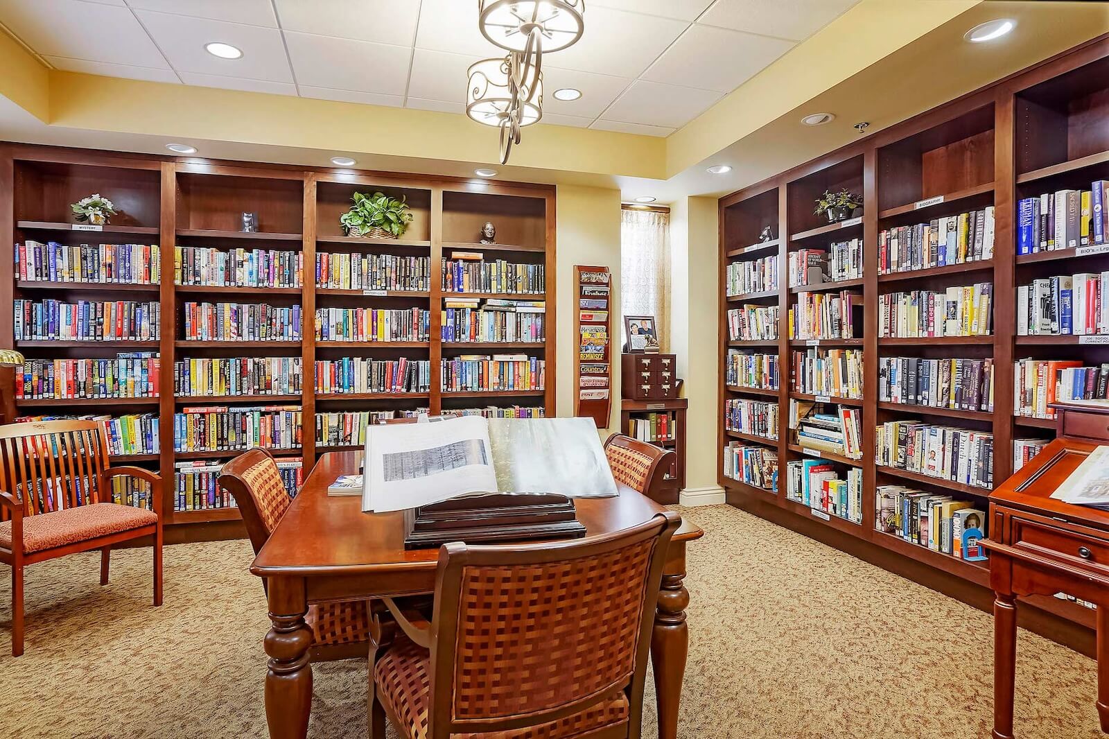 Library with walls of full bookshelves and a table in the middle with a large book