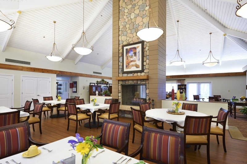 Dining tables and a large fireplace at a restaurant at The Terraces at San Joaquin Gardens