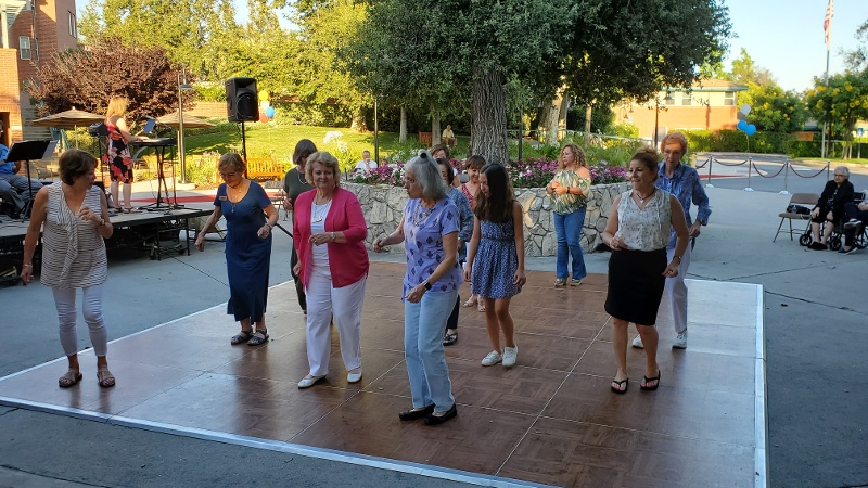 Women line dancing in the middle of a park