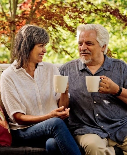 Senior couple drinking coffee on the porch.