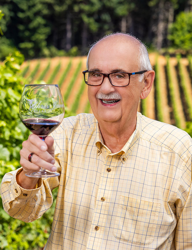 senior man smiling while holding a wine glass
