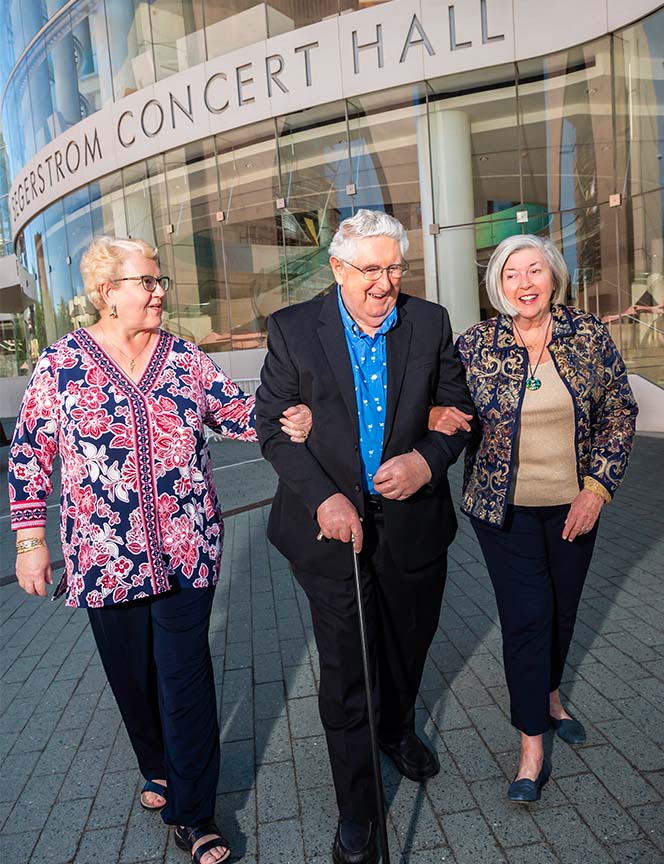 Three senior friends walking from a concert hall