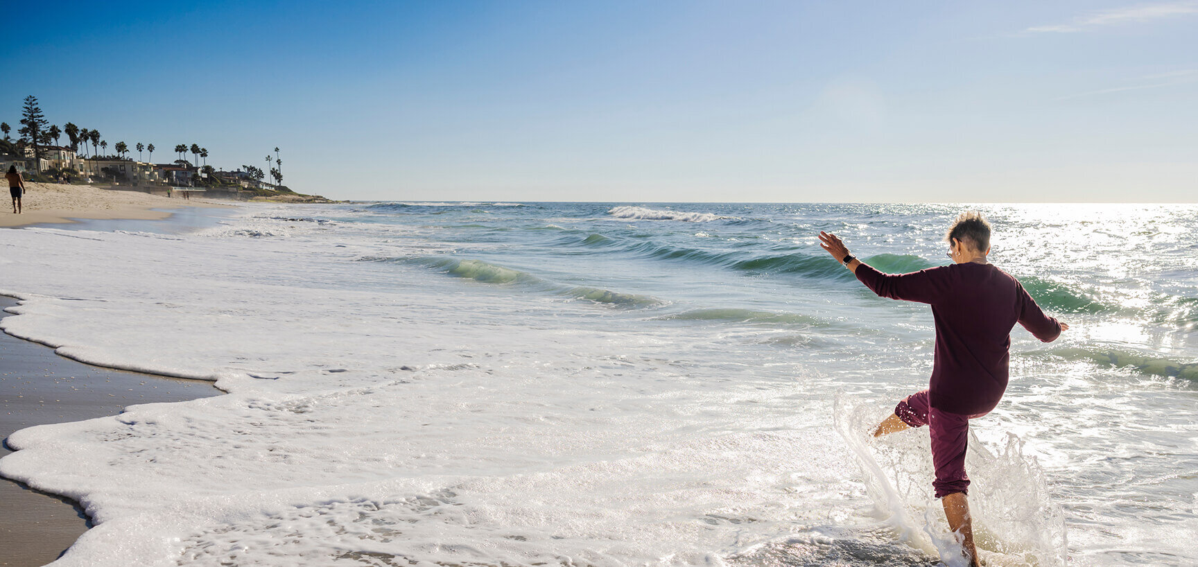 senior splashing in water on the beach