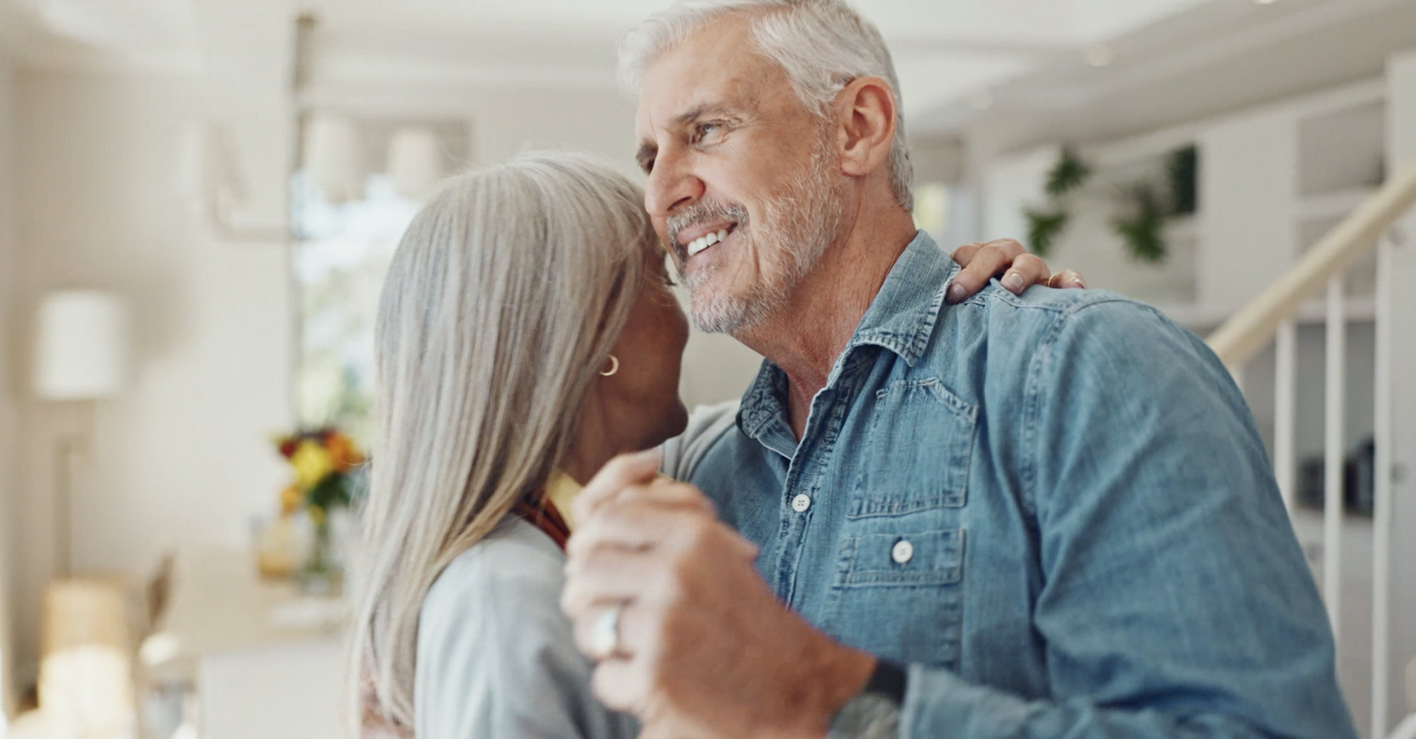 Senior couple dancing in their home