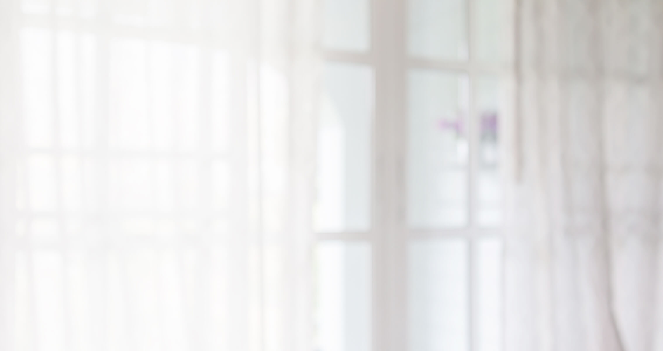 blurred background of a window with sheer curtains during dayight