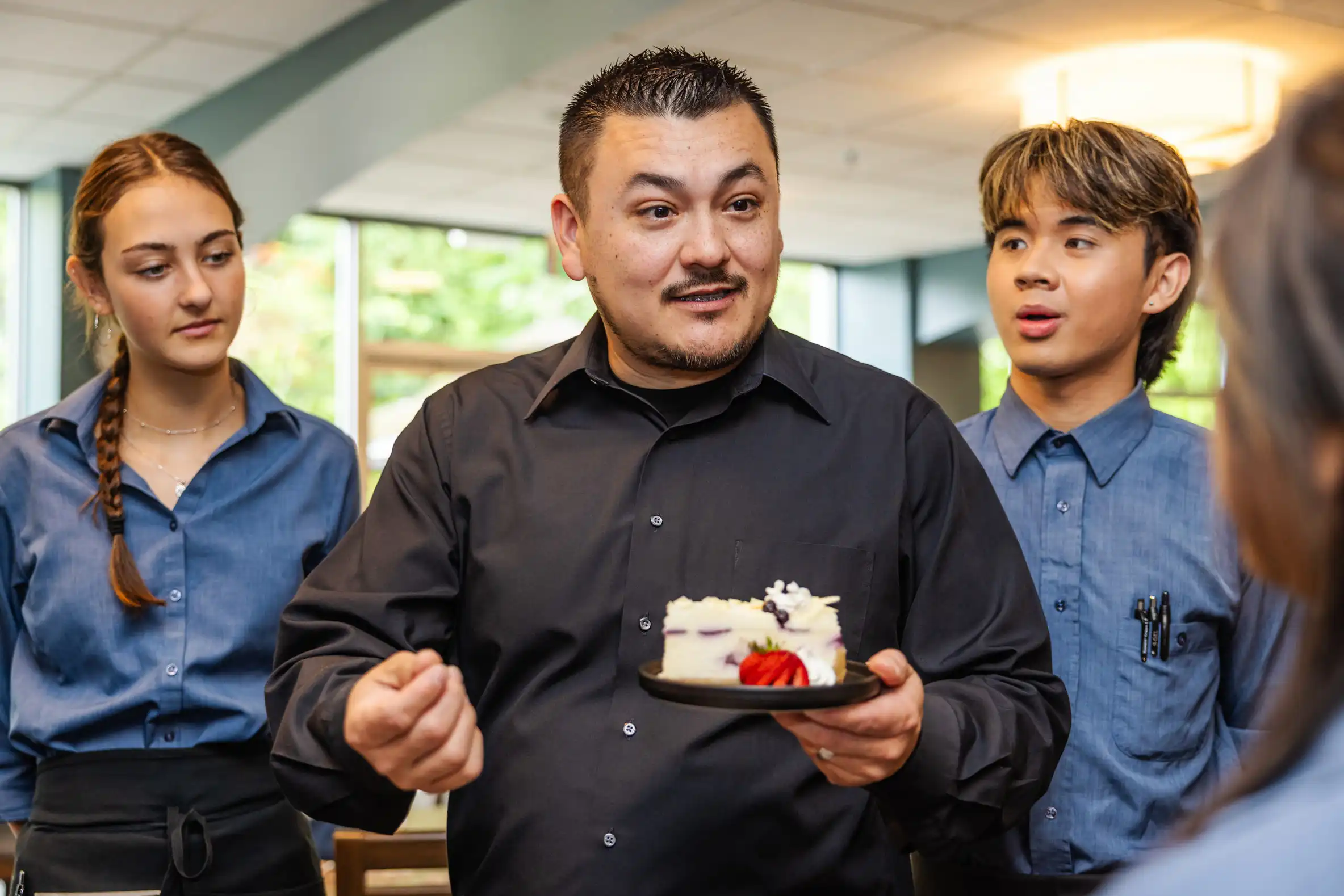 restaurant manager speaking to servers at staff meeting