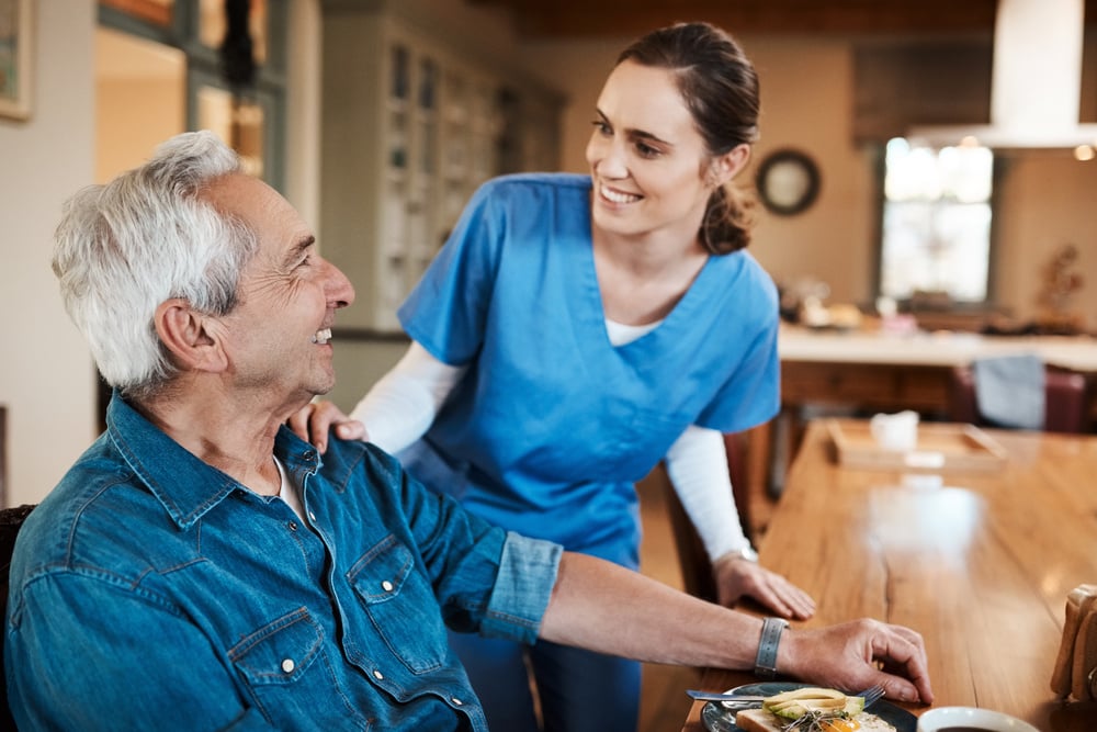 women assisting man in assisted living community