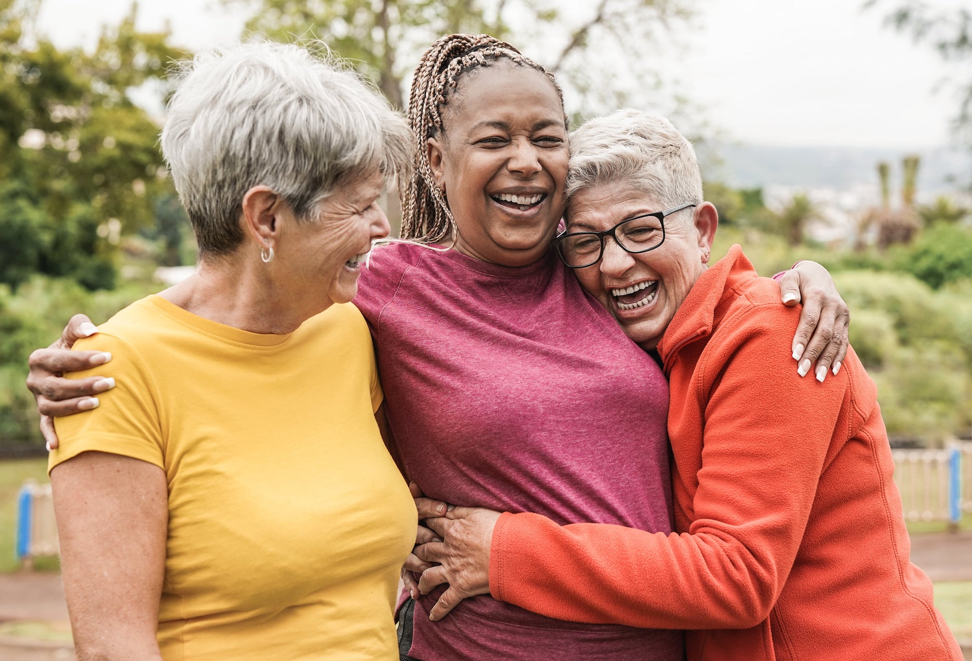 three women hugging outside