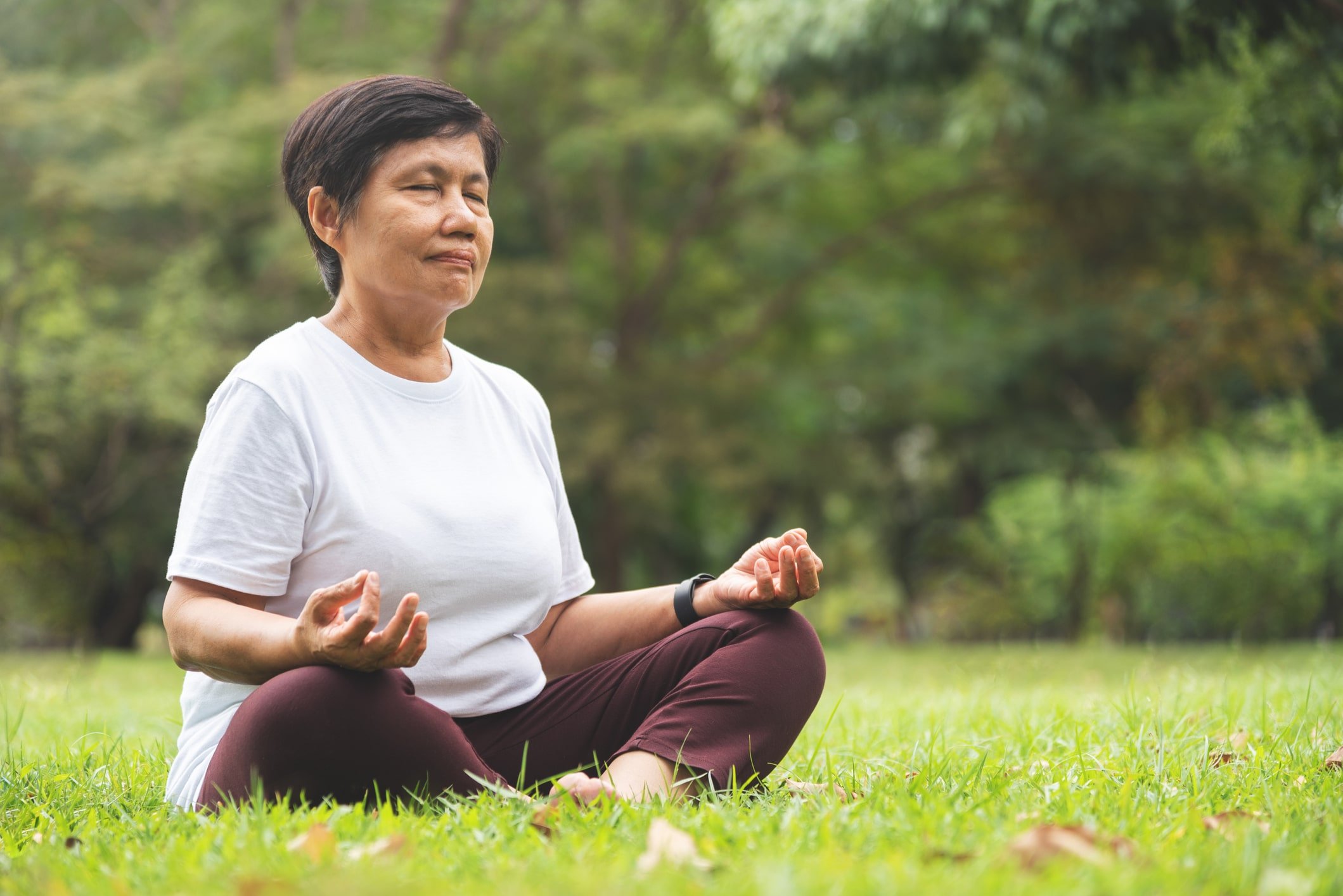 Older woman meditating outside