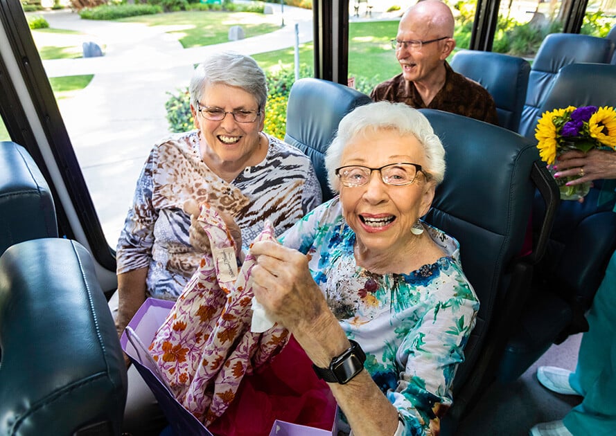 Residents of Rosewood laughing in the bus to an excursion.