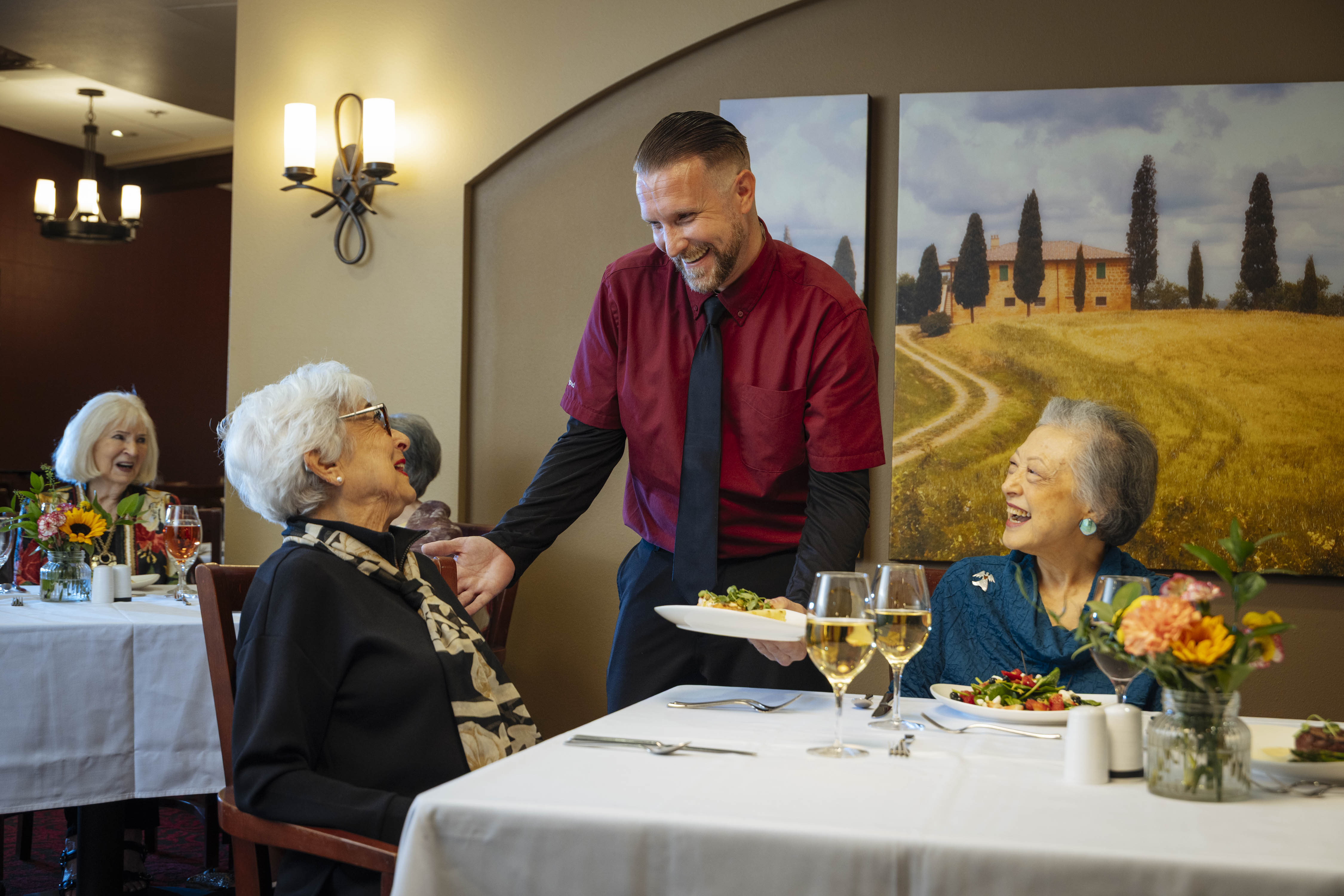 Waiter serving women their plates.
