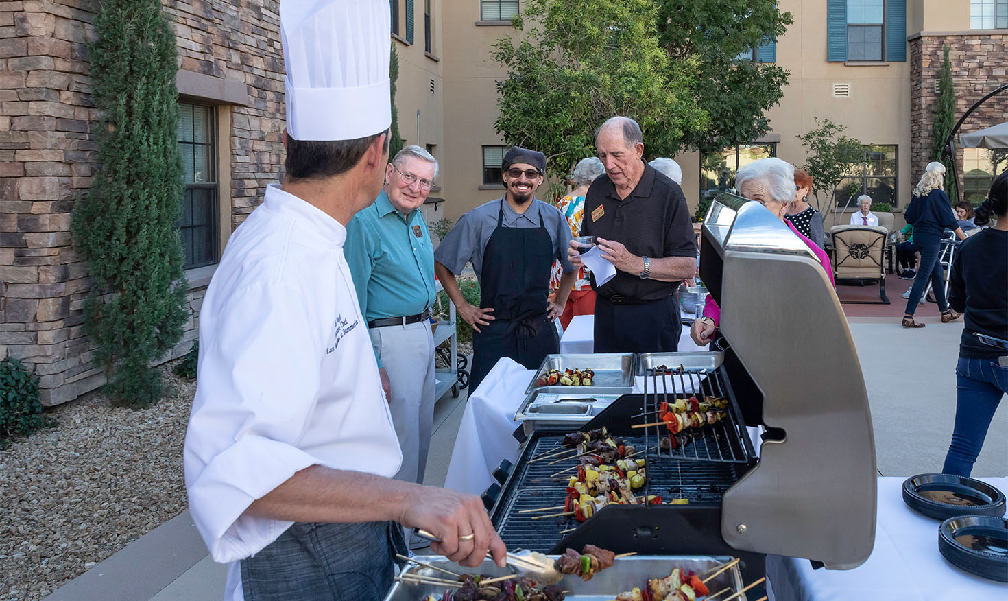 Chef cooking food for residents on the grill outside