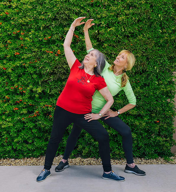 Senior woman doing stretches with a trainer