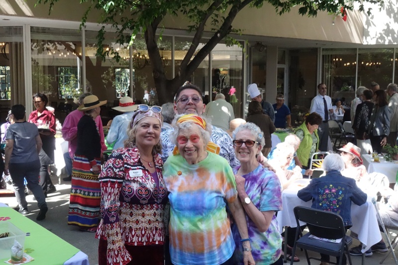 A smiling group of people wearing tie-dye and bright colors.