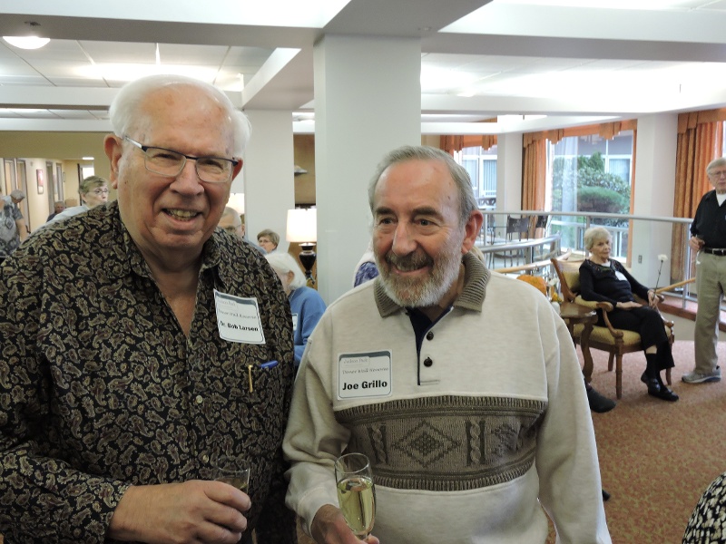 Two men smiling with champagne glasses at the Judson Park Foundation event.