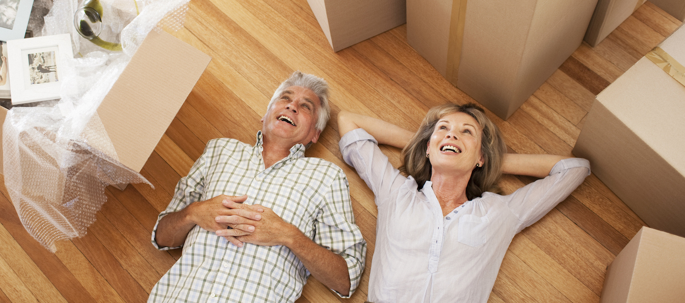 couple laying down on floor with moving boxes