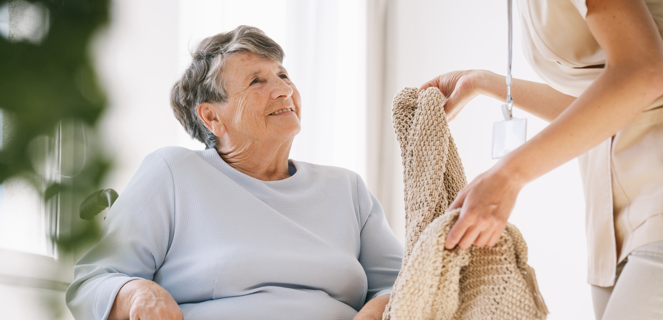 nurse giving senior woman blanket