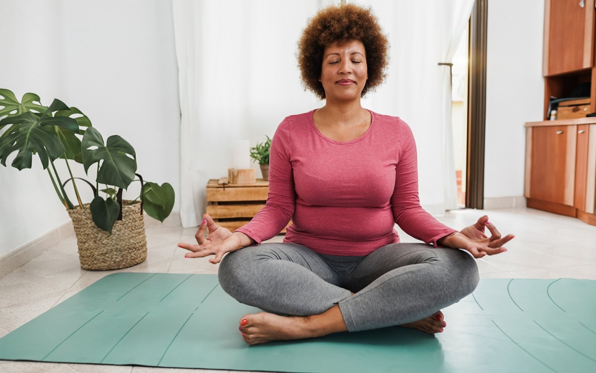 Woman meditating on a yoga mat. 