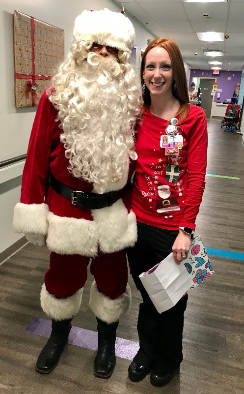 Resident dressed as Santa with a hospital staff member.