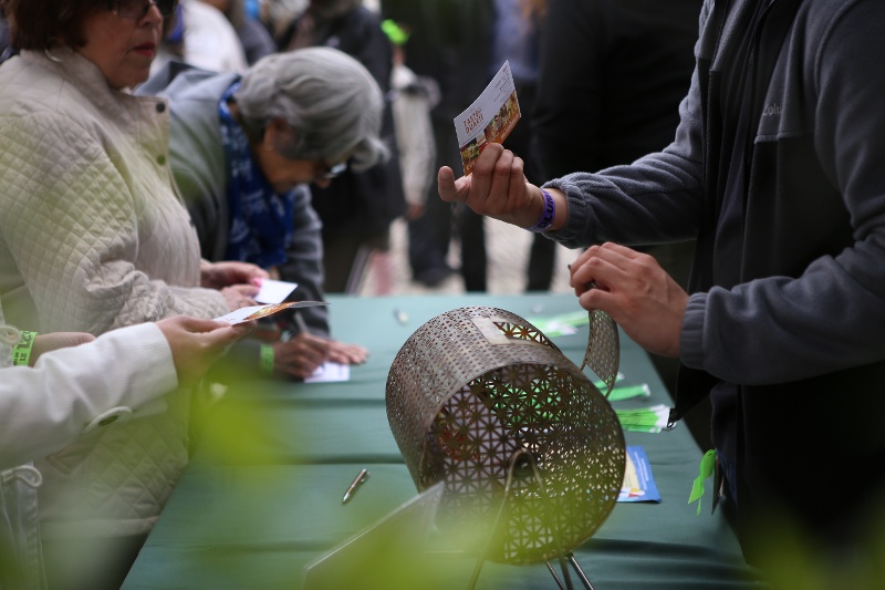 People writing their names on raffle tickets.