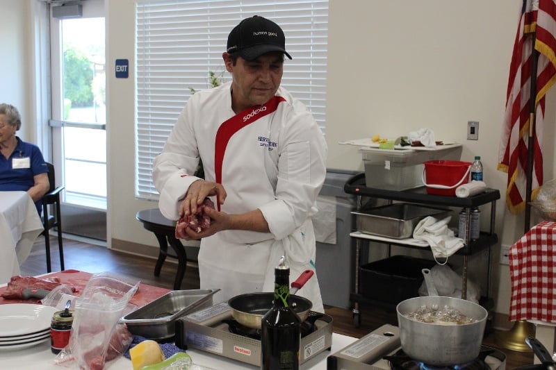 A chef rolling meat in his hands