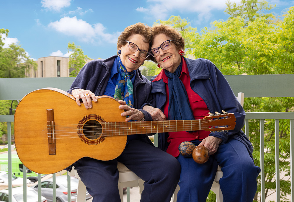 Barbara and Carole holding musical instruments