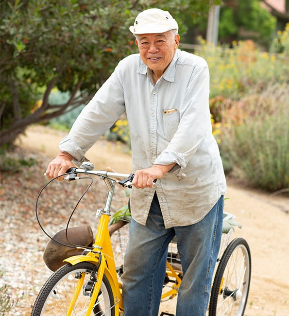 Danny standing next to a yellow bicycle