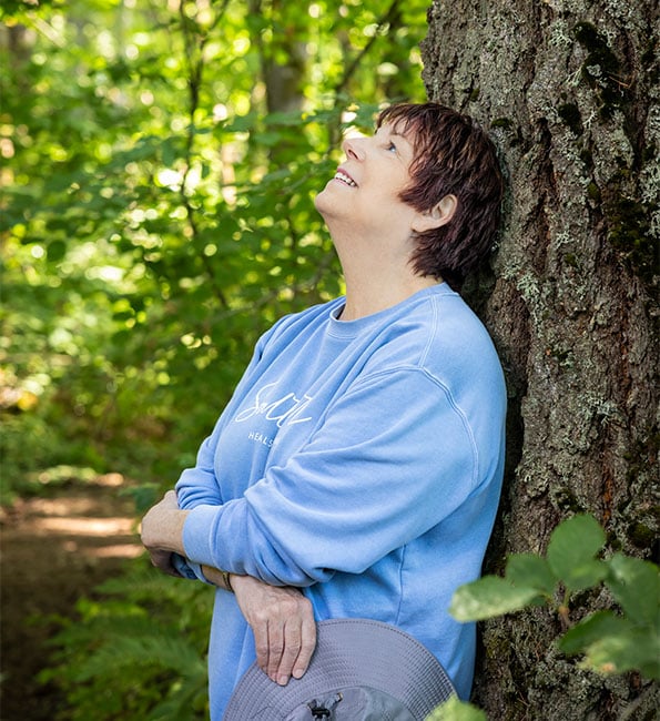 Erin leaning on a tree