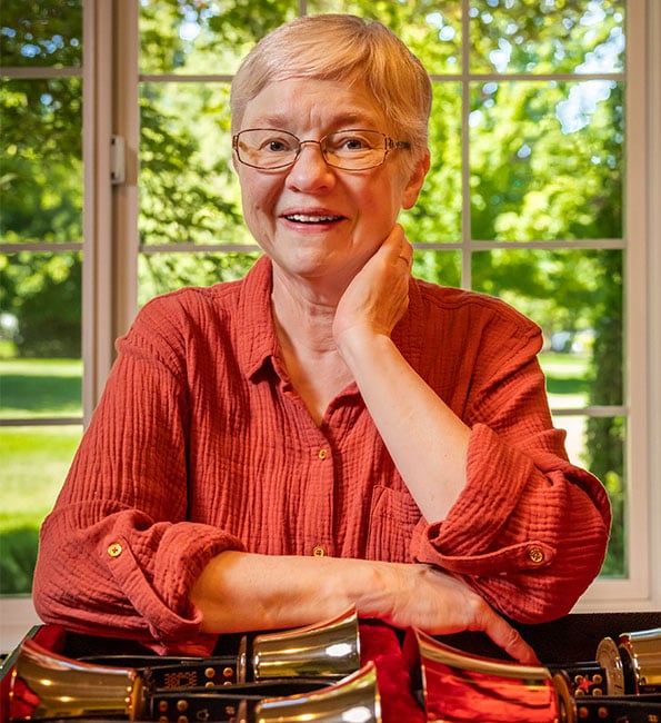 Marcia posing and smiling next to musical instruments