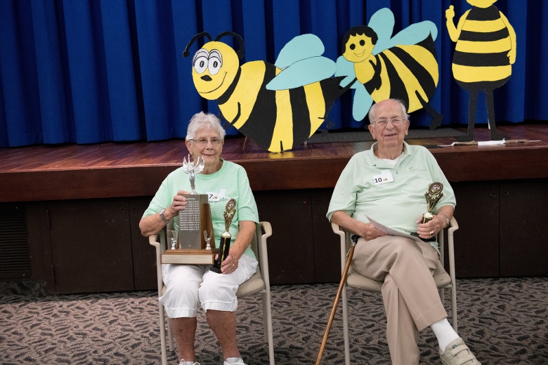 Spelling bee champions hold their trophies.