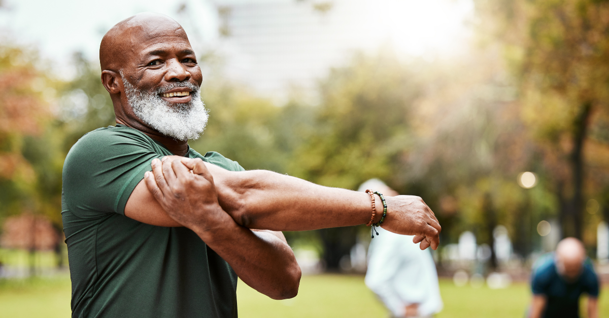 man smiling and stretching outside in yard