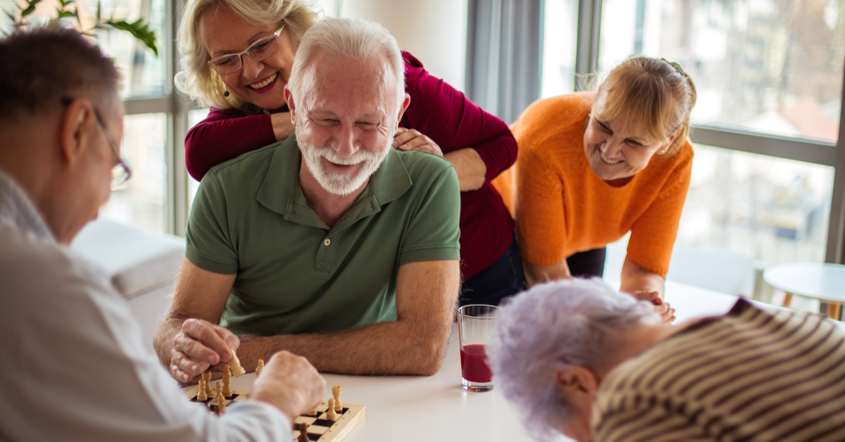 group of seniors playing chess together and laughing