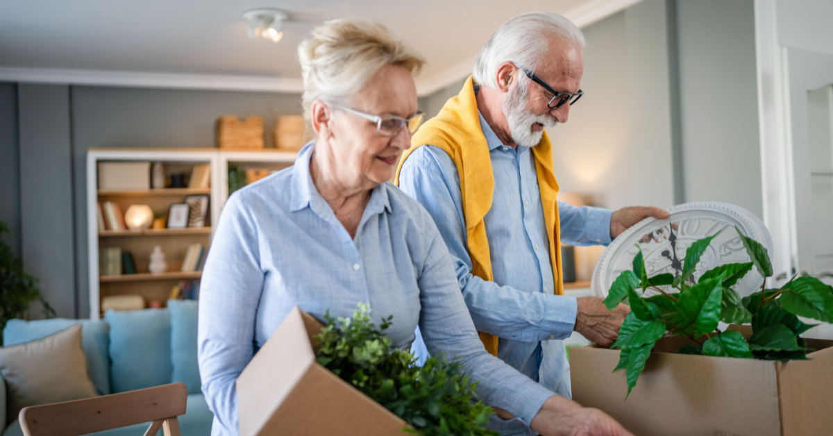 elderly man and woman packing boxes to organize their home