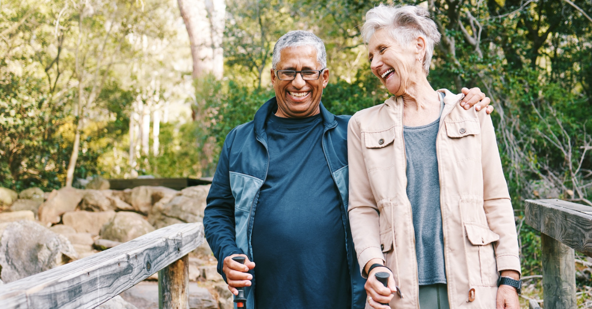 man and woman walking outside across a wooden bridge