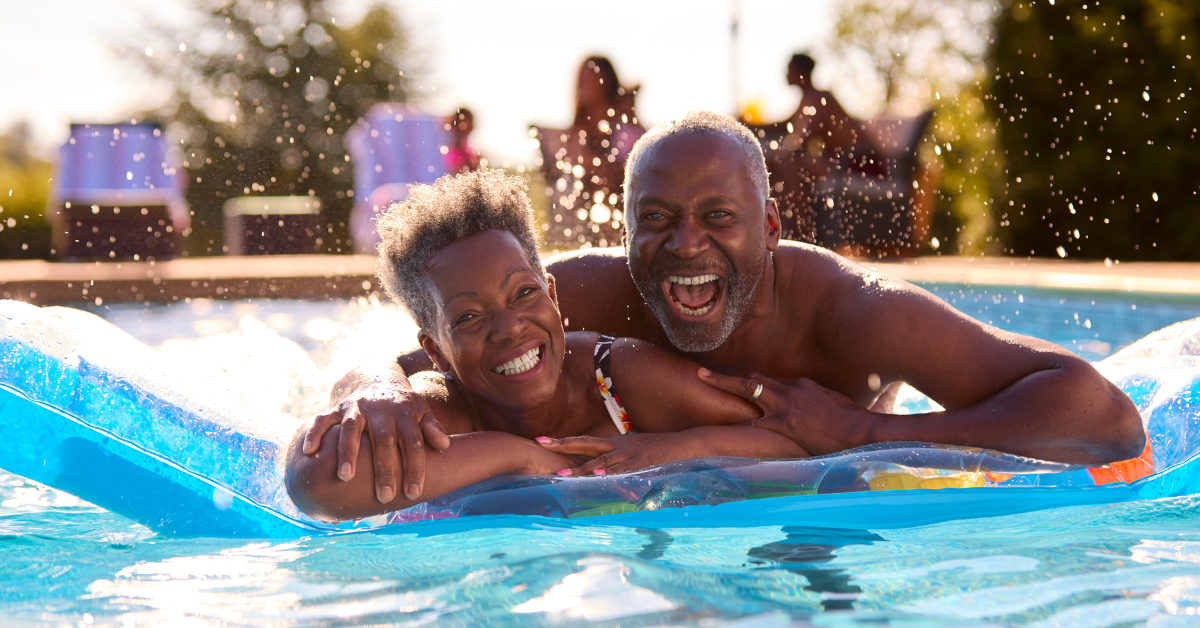 older couple smiling and embracing on a pool float