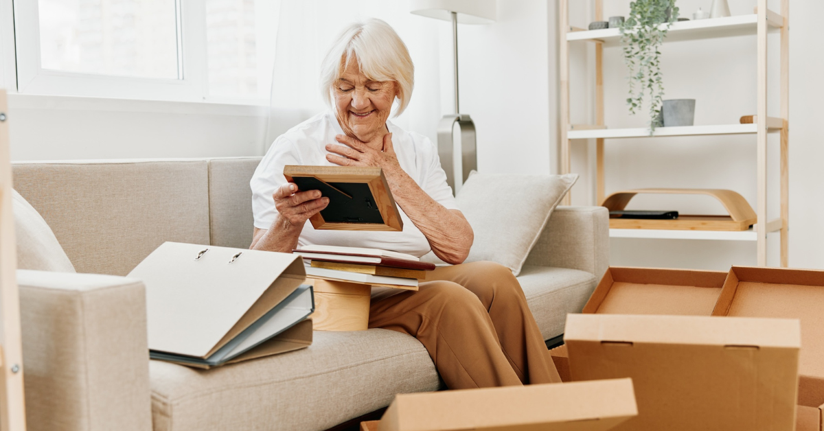 older woman sitting on couch looking at old photos