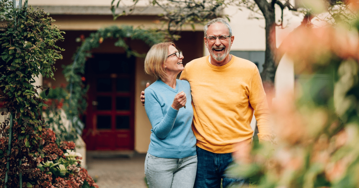 senior couple smiling outside in garden