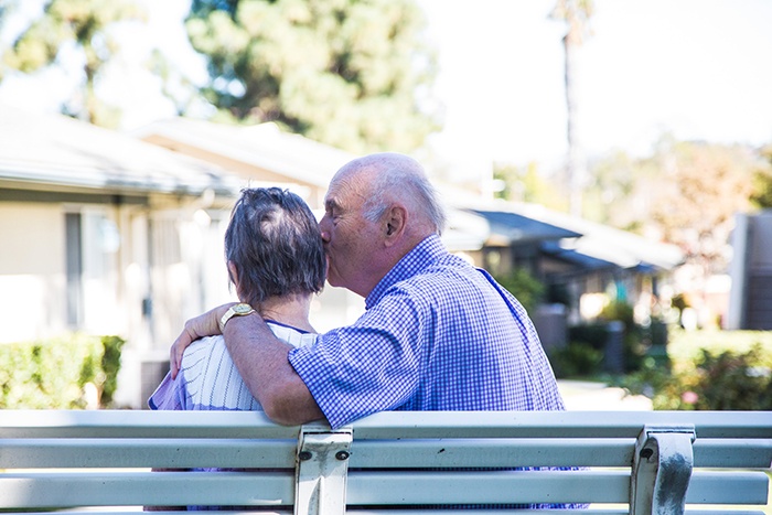 seniors cuddling on bench