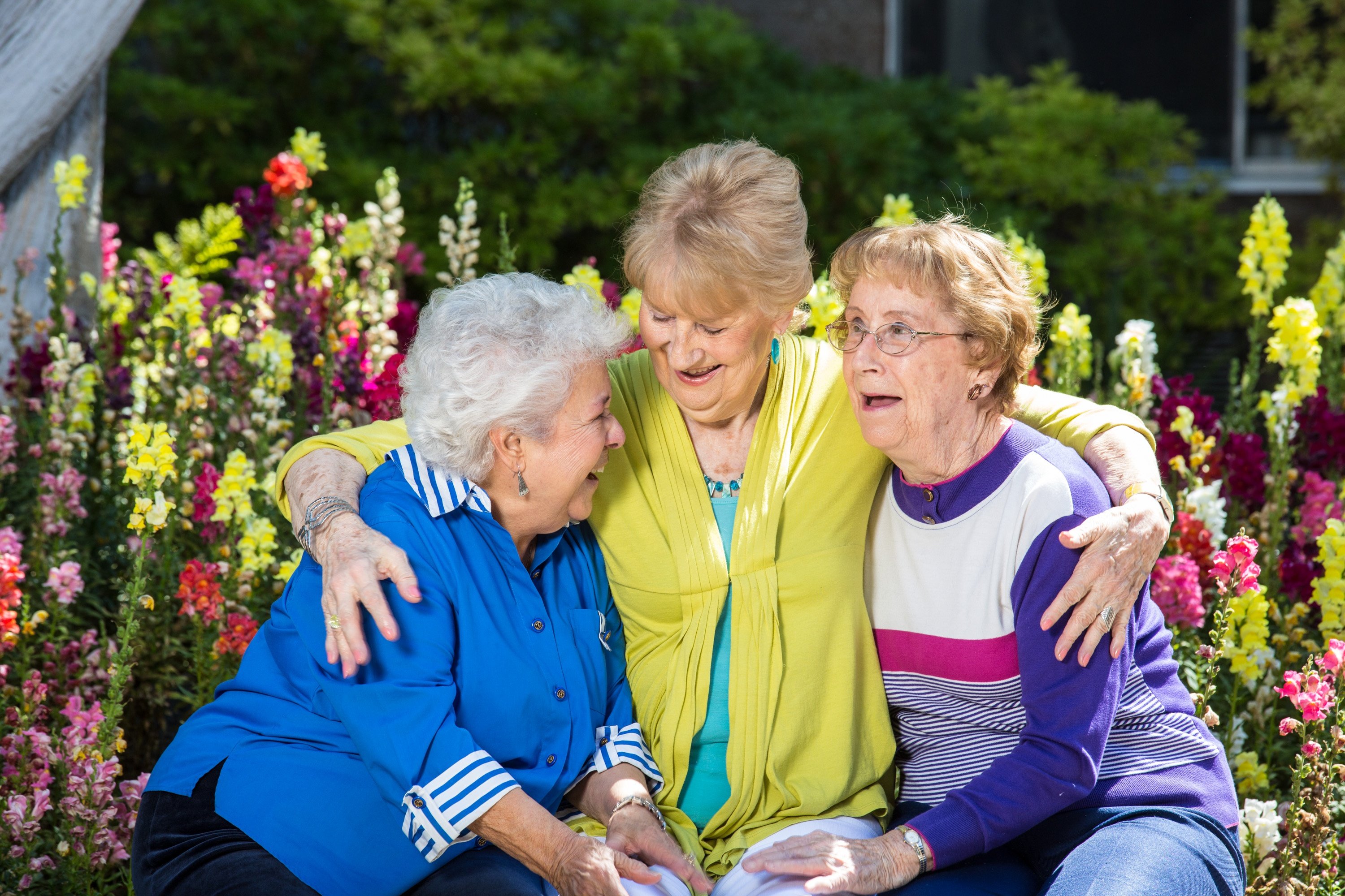 Three women laughing and hugging