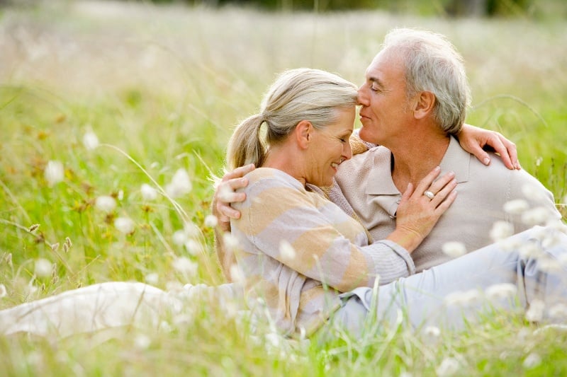 A senior couple embracing in the grass