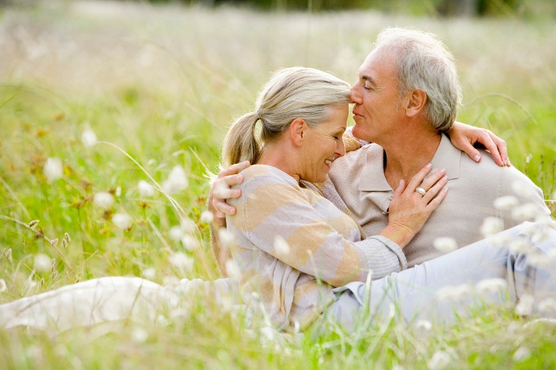 A senior couple embracing in the grass