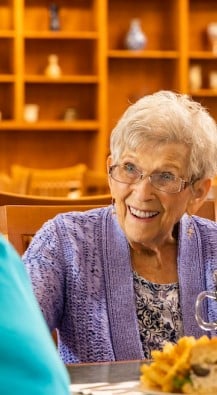 Woman sitting at a table talking to another person