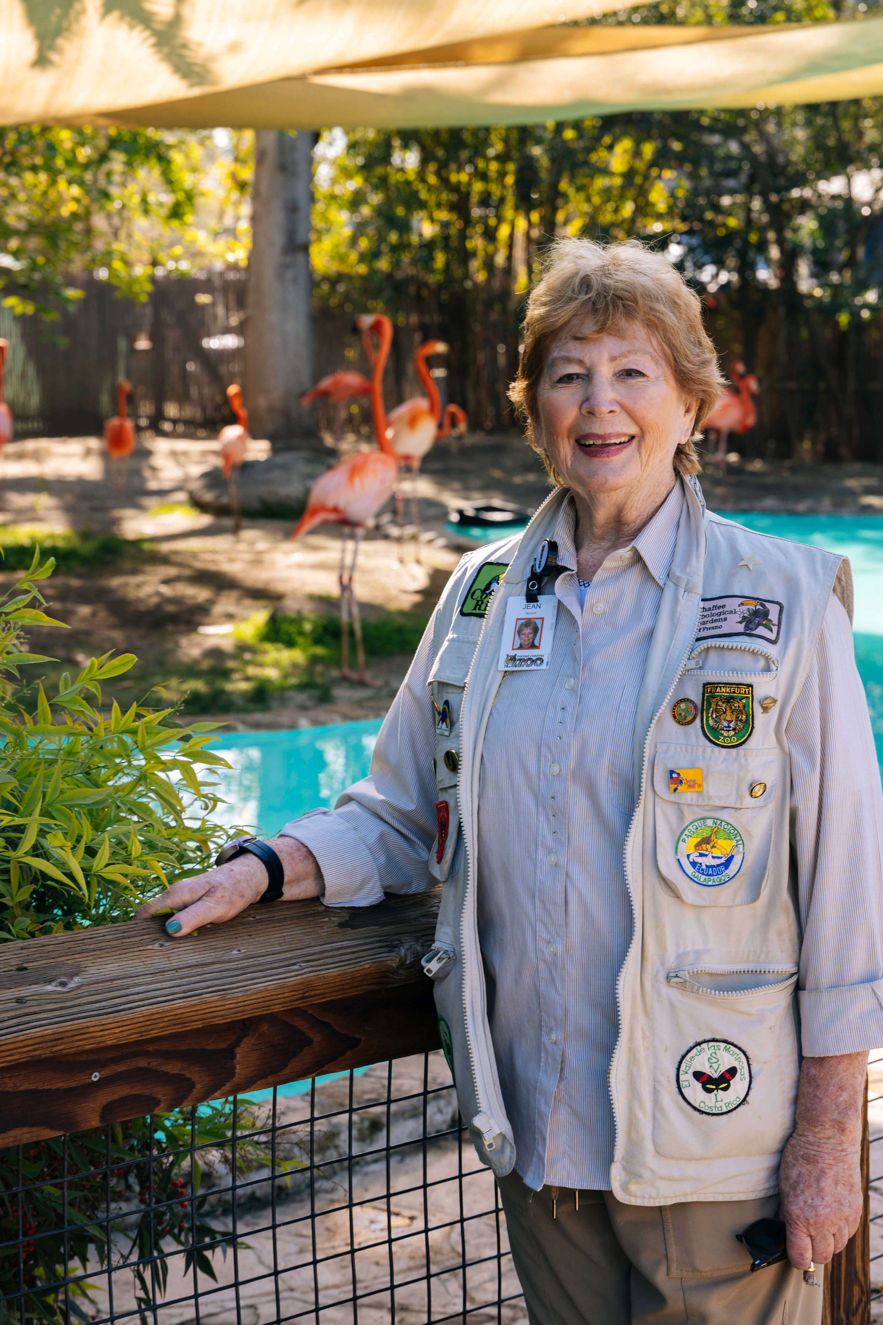 Jean is standing outside in front of a flamingo exhibit
