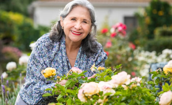 Senior woman posing near flowers