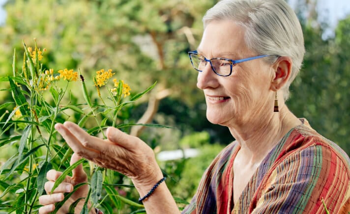 Senior woman touching flowers